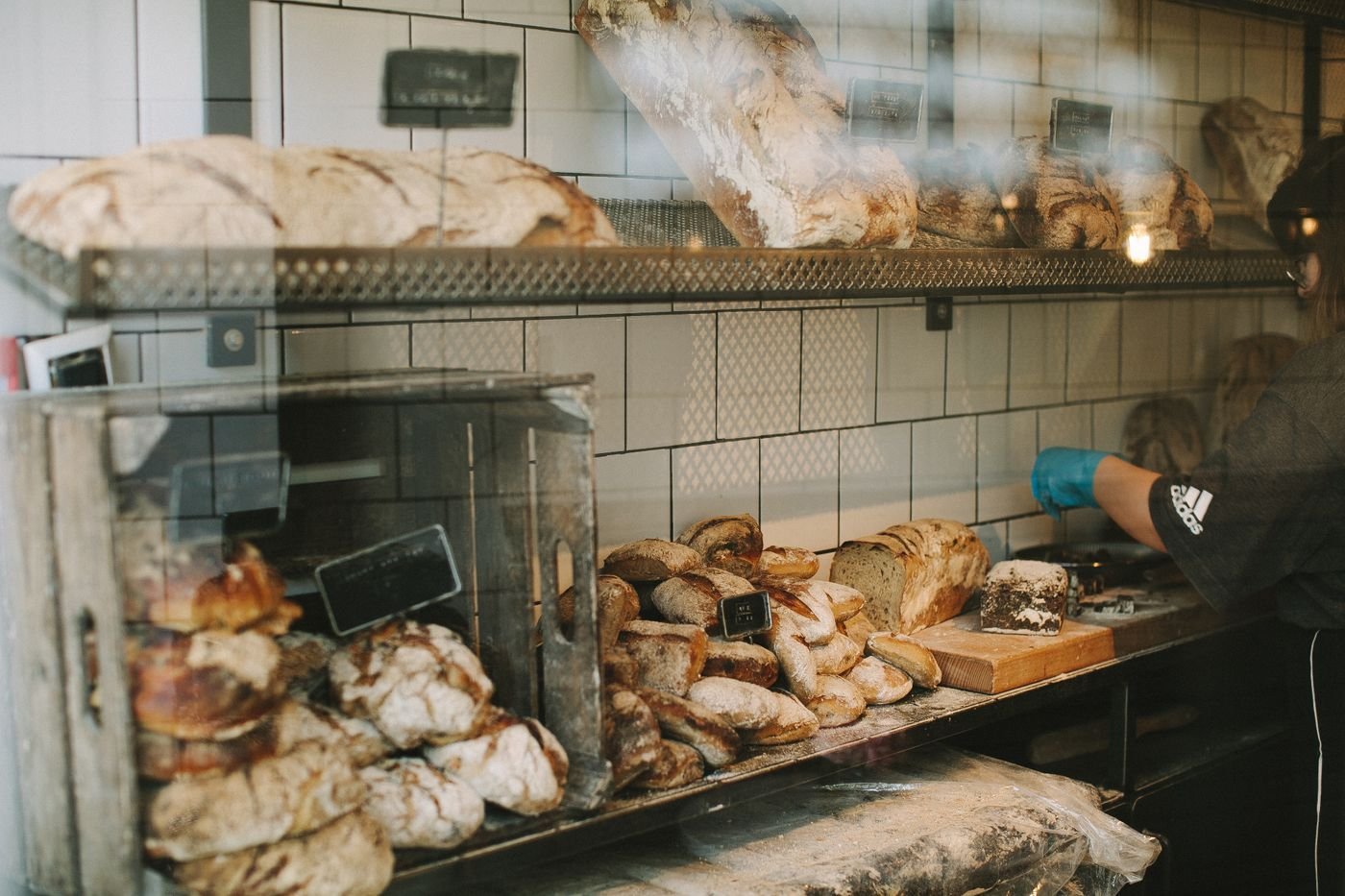 Shelves of fresh loaves and pastries behind a bakery counter